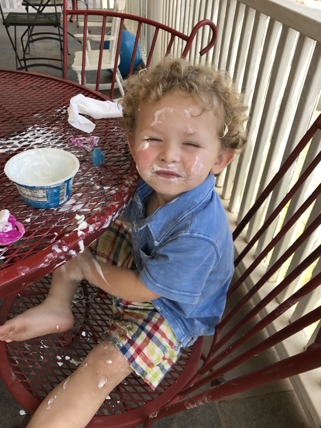 curly haired two year old covered in yogurt