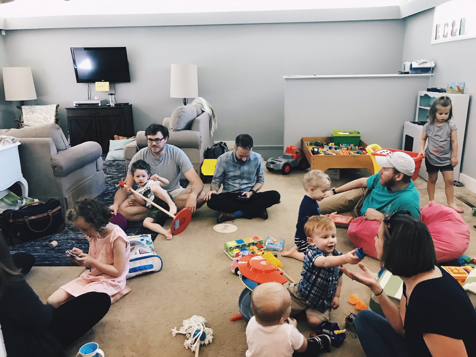 Adults and kids in a messy room.
