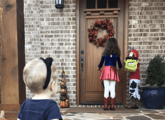 Three kids in costumes on a front porch.